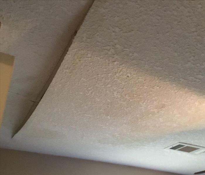 A ceiling is shown with water damage after a storm