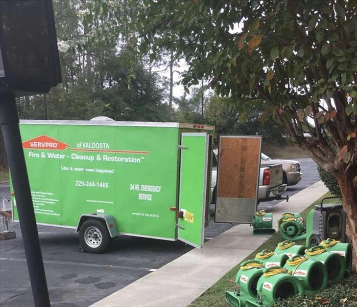 A green SERVPRO trailer is shown on a job