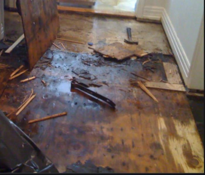 Wet floors are shown in a storm damaged home