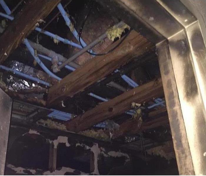 Fire damage in a ceiling of a commercial building is shown